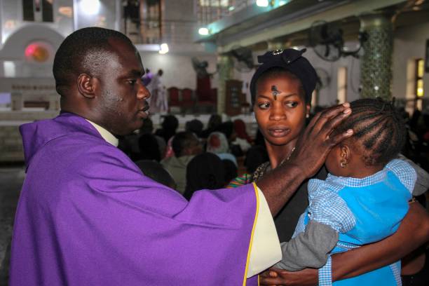 A priest signs the forehead of a child as catholics take part in the Ash Wednesday celebration at the St. Patrick cathedral in Maiduguri on February 26, 2020. (Photo by AUDU MARTE / AFP) (Photo by AUDU MARTE/AFP via Getty Images)