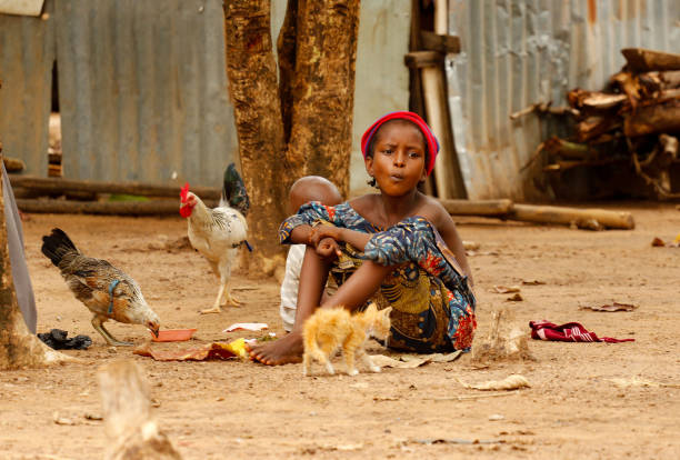 ABUJA, NIGERIA - MAY 24: A girl sits with her baby sibling around pets at Durumi Internally Displaced Persons (IDPs) camp in Abuja, Nigeria on May 24, 2023. Civilians displaced due to increasing security problems in northeast Nigeria, are struggling to survive in makeshift tents. (Photo by Emmanuel Osodi/Anadolu Agency via Getty Images)