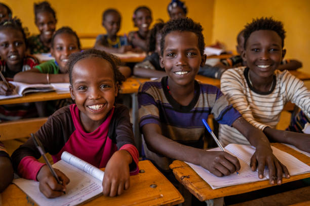 African children during english class in very remote school. The building is new, but still there is no light and electricity inside the classroom.